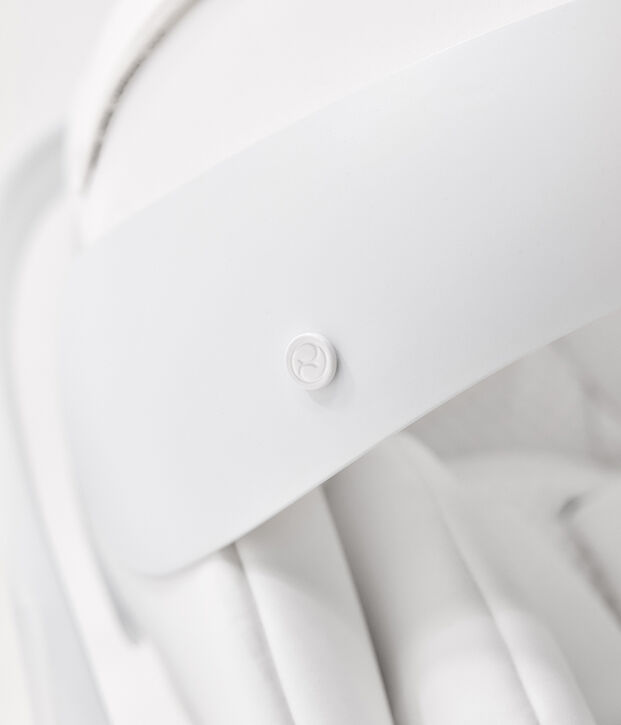 A white, modern design object with a small round button in the centre.