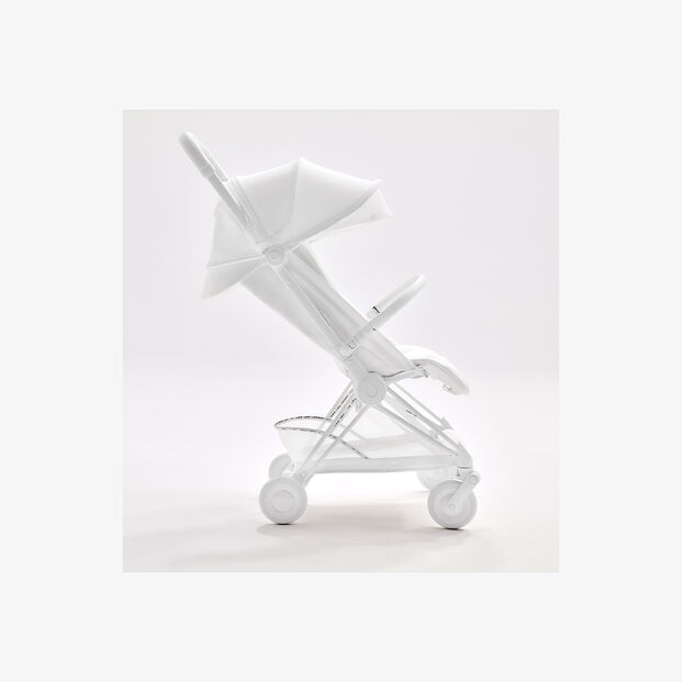 White stroller in a side profile, showcasing a sleek and contemporary design.