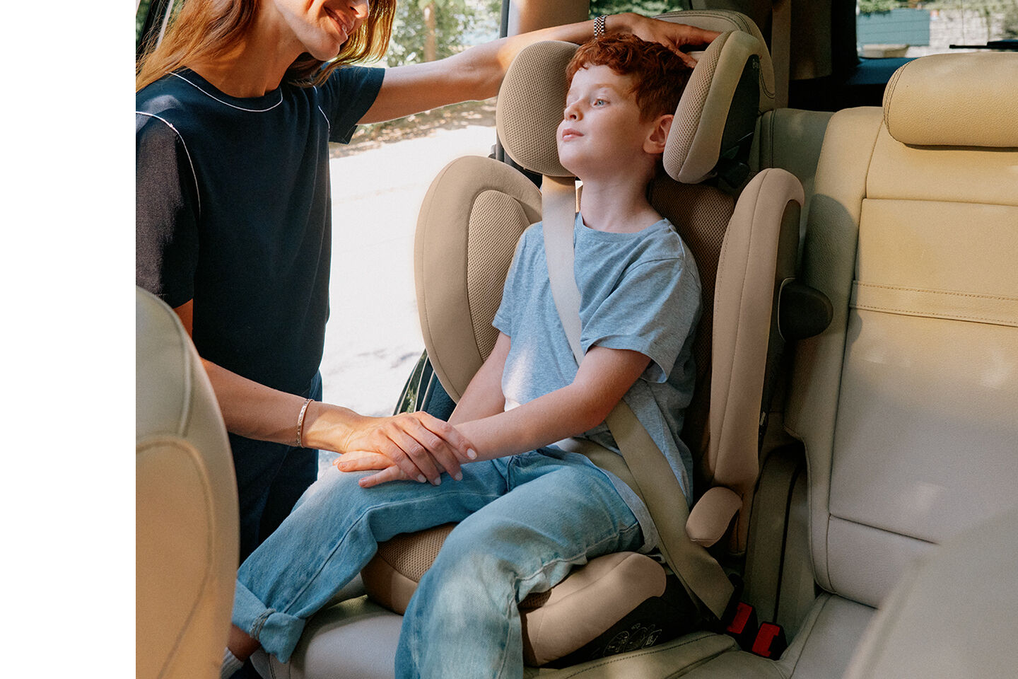 Mother securing her child in the Solution G2 travel car seat in a car.