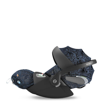 A black car seat with blue floral patterns and a carrying handle.