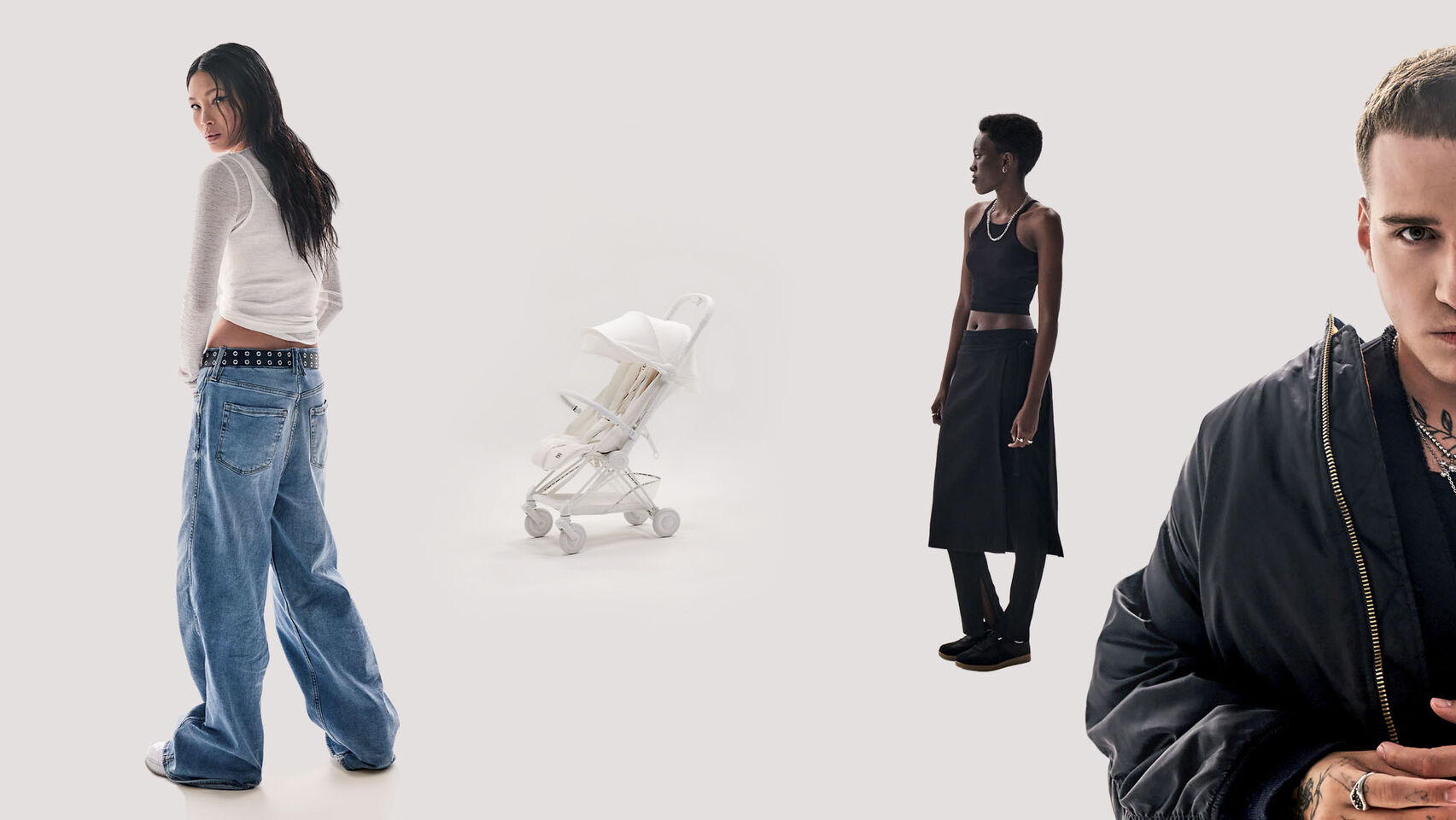 A group of four people in fashionable clothing stands around a white stroller.