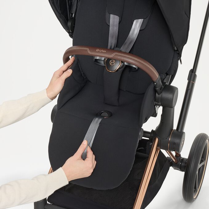 Ein Bild des CYBEX Platinum Priam Stroller, das das Merkmal Einhand-Gurtsystem hervorhebt.