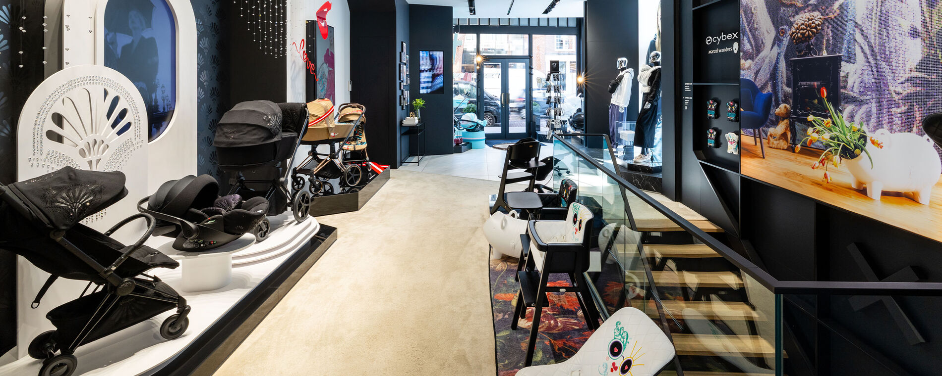 Ein Blick ins Innere des Flagship-Stores in Amsterdam: Mehrere CYBEX Kinderwagen, Kindersitze, Babywippen, Rocker und weitere Produkte sind ordentlich nebeneinander pr&auml;sentiert.