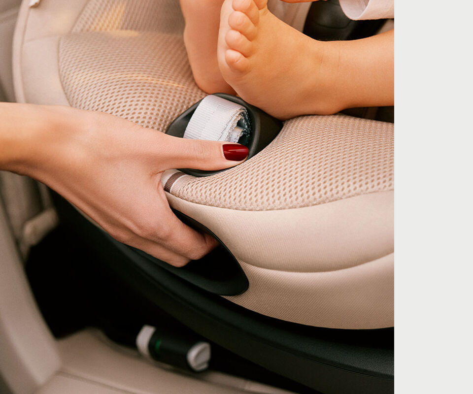 Gros plan d&rsquo;une femme en train de faire pivoter le si&egrave;ge auto Sirona G i-Size.