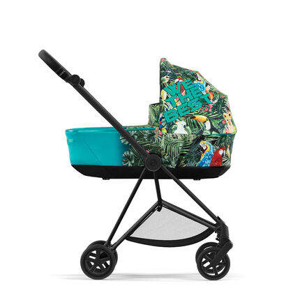 Side view of a by DJ Khaled stroller with tropical design and parrot motif.