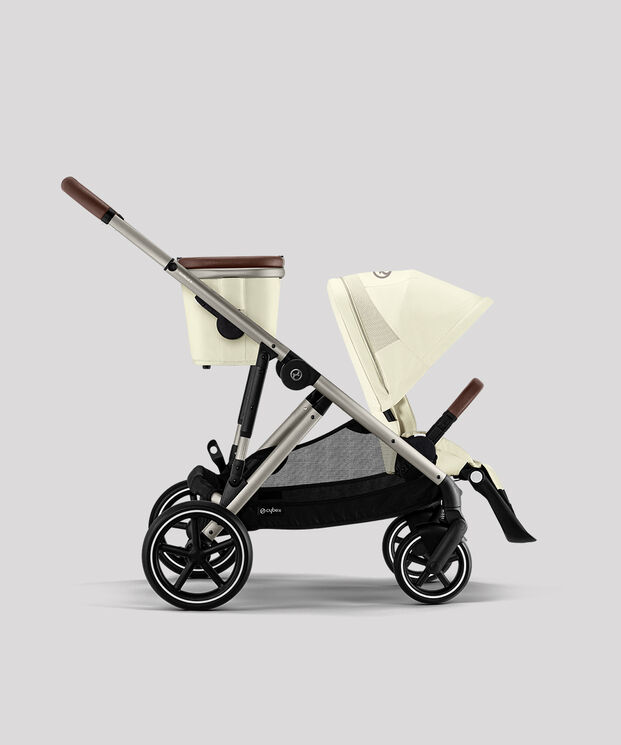 Beige pushchair with brown handles, side view.