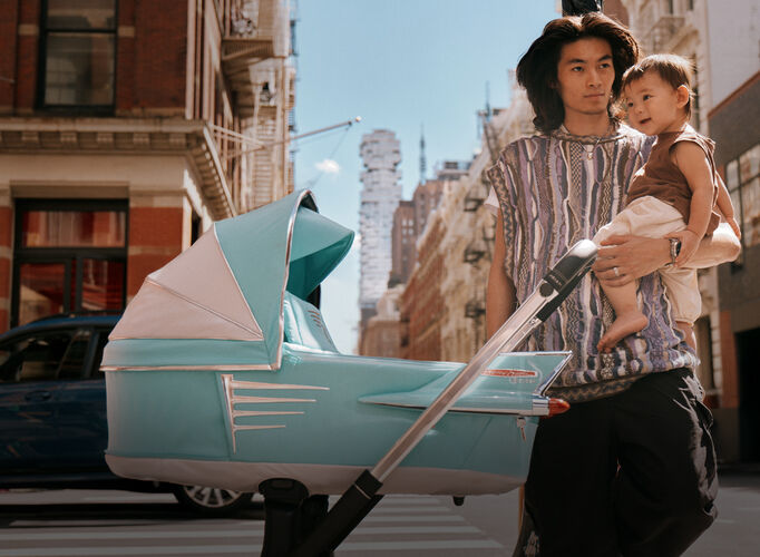 A man with his son standing behind a CYBEX by Jeremy Scott stroller.