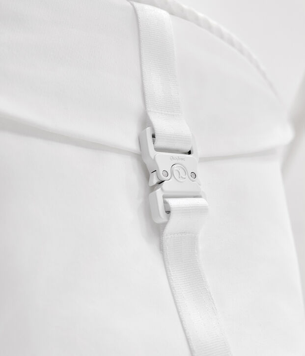 A white strap with a buckle on a backpack.