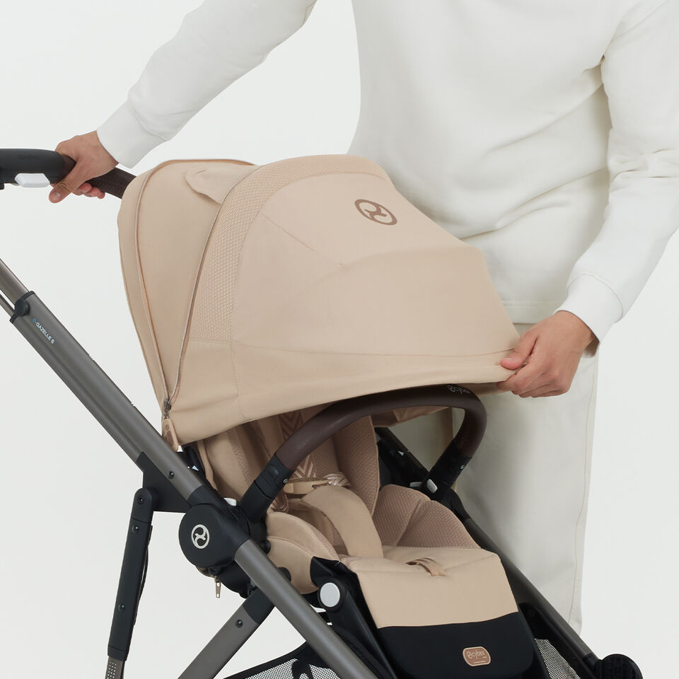 A woman pushing a Balios S Lux pushchair, the sun canopy completely down.