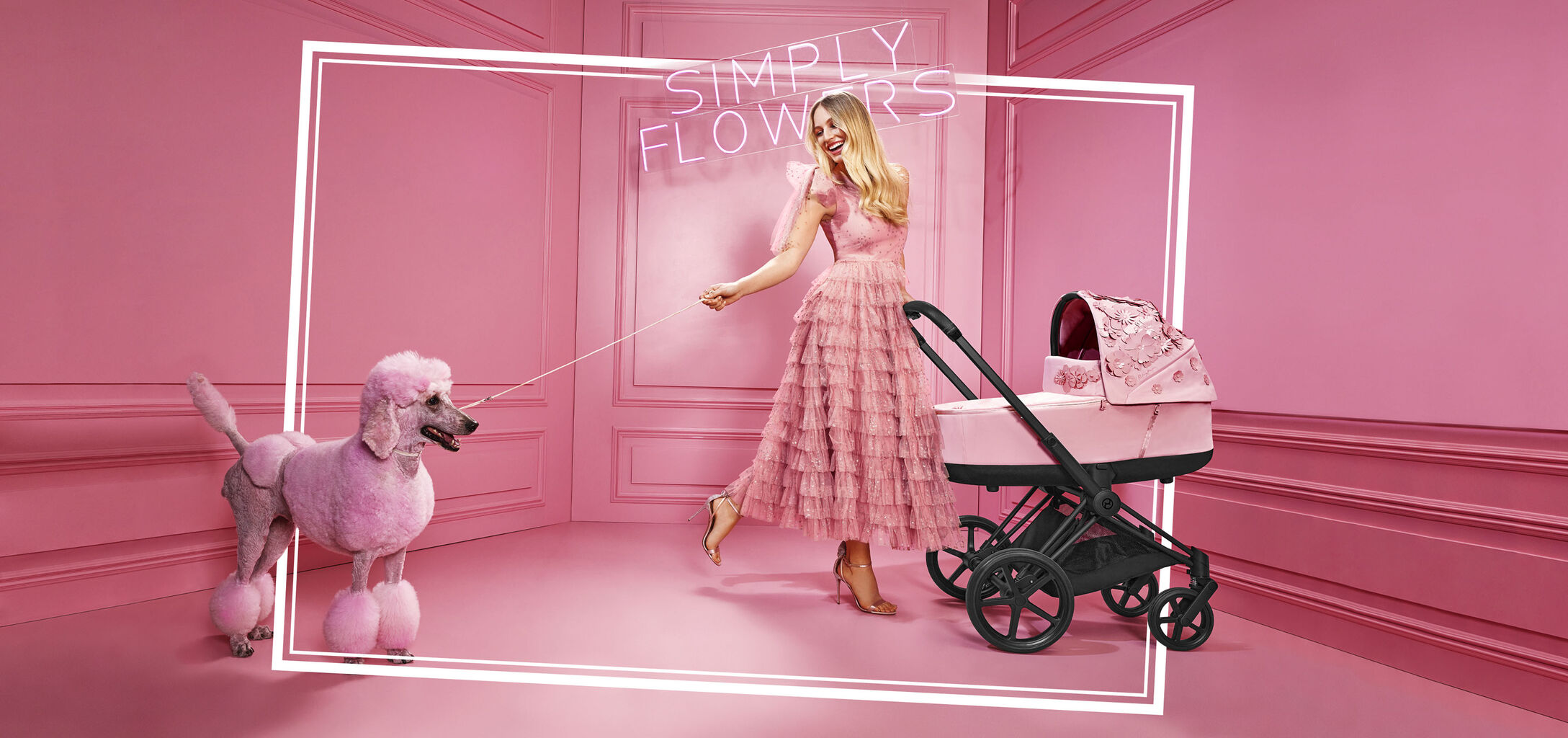 Kvinna i rosa kl&auml;nning med en rosa pudel och en CYBEX Simply Flowers barnvagn i ett rosa rum.