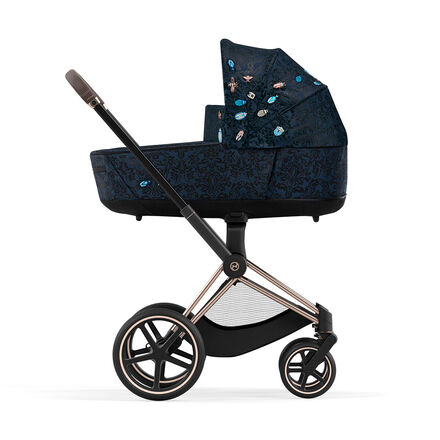 Pram with dark blue pattern and embroidered canopy, side view.