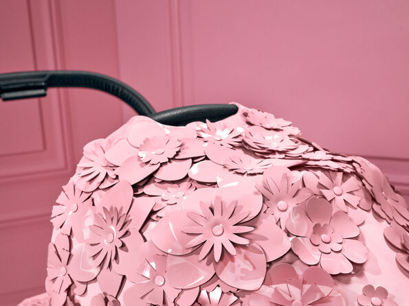 CYBEX Simply Flowers barnvagn med rosa blomm&ouml;nster mot en rosa bakgrund.