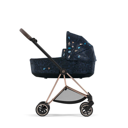 Pram with dark blue fabric and floral pattern, side view.