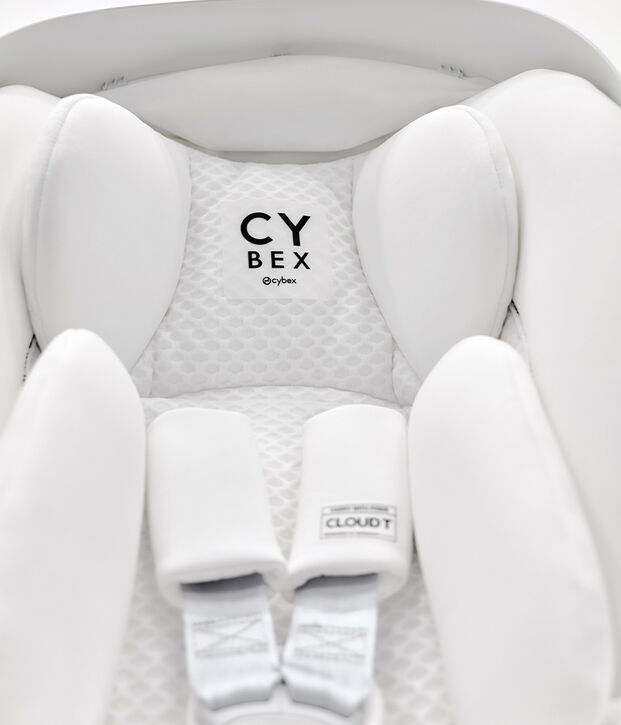 Un seggiolino auto Cybex bianco con un&rsquo;imbottitura morbida e cinture di sicurezza.