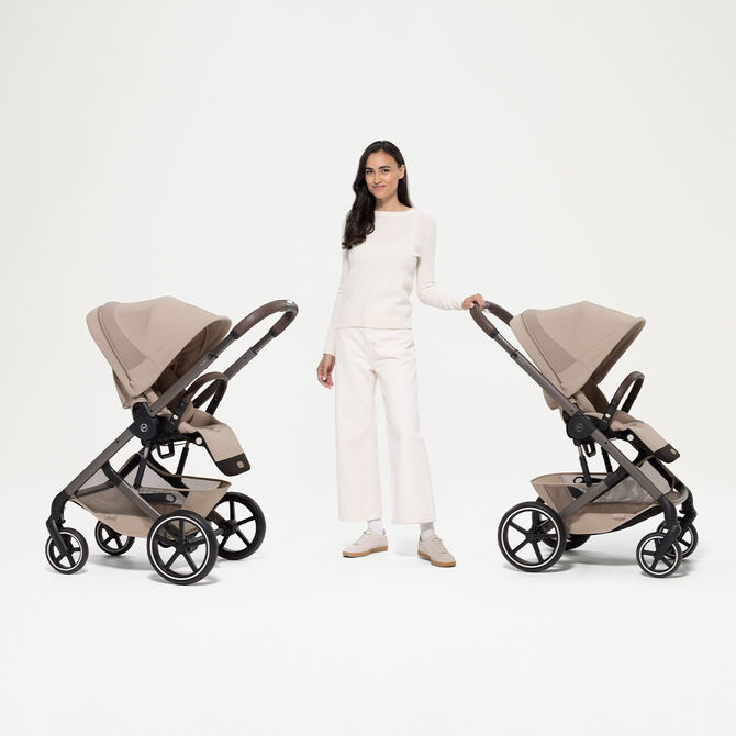 Eine Frau neben zwei Balios S Lux Kinderwagen. Links zeigt das Sitzpaket zu ihr, rechts, in die andere Richtung.