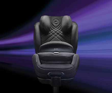 Anoris T2 i-Size Plus Kindersitz mit Airbag vor dunklem Hintergrund, frontal aufgenommen