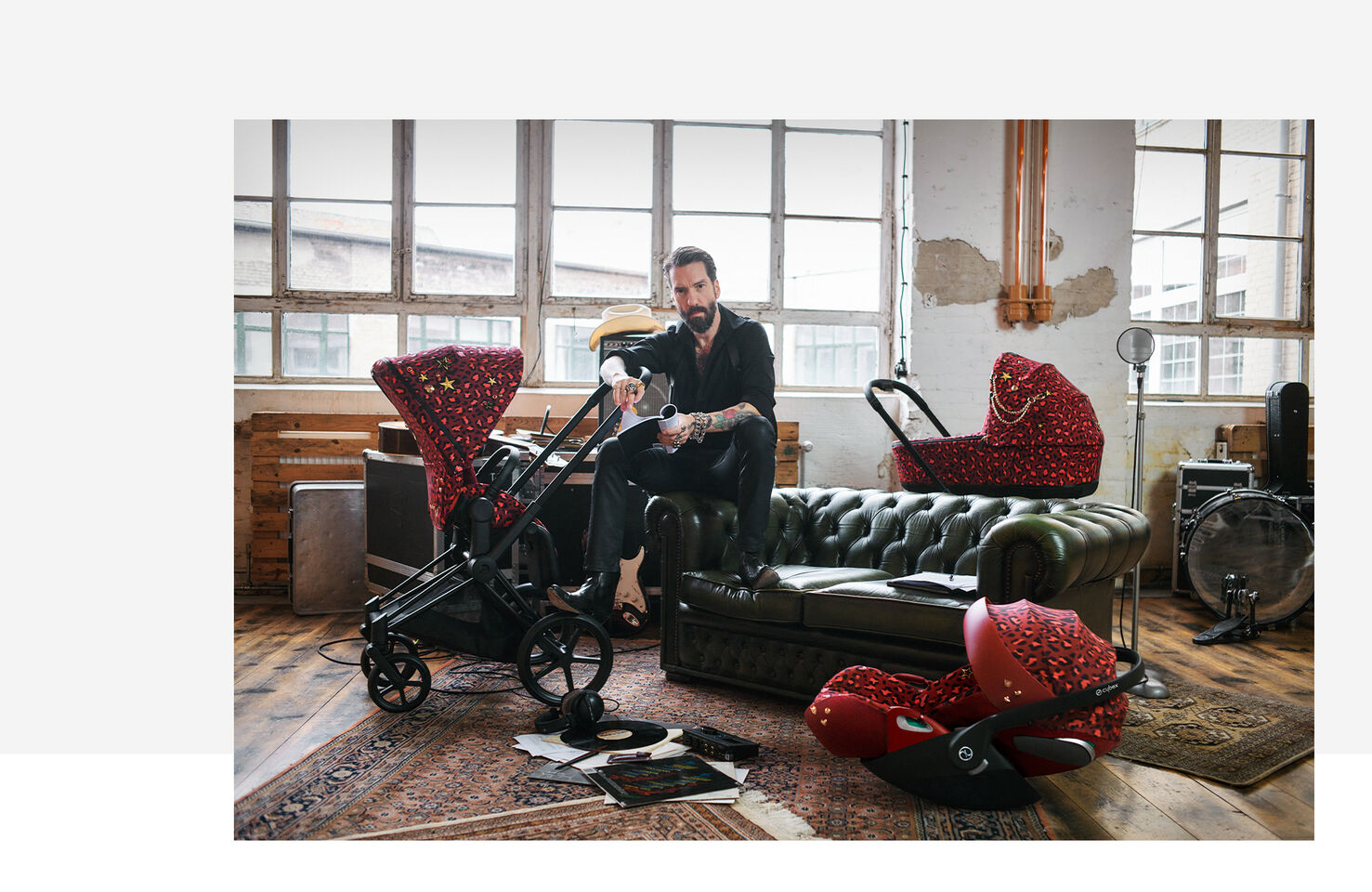 CYBEX Rockstar Kinderwagen in einem stilvollen Raum mit einem Mann auf einem Ledersofa sitzend.