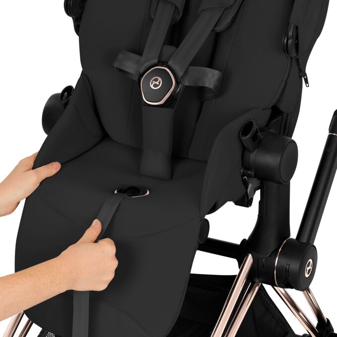 Ein Bild des CYBEX Platinum e-Priam Rebellious Luxury Stroller, das das Merkmal Einhand-Gurtsystem hervorhebt.