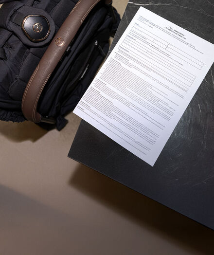 A document on the right, a folded up CYBEX stroller on the left.