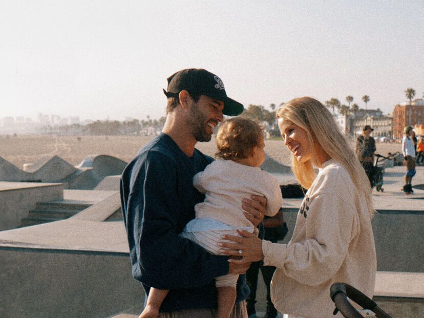 Family with a toddler at a skate park, smiling and relaxed
