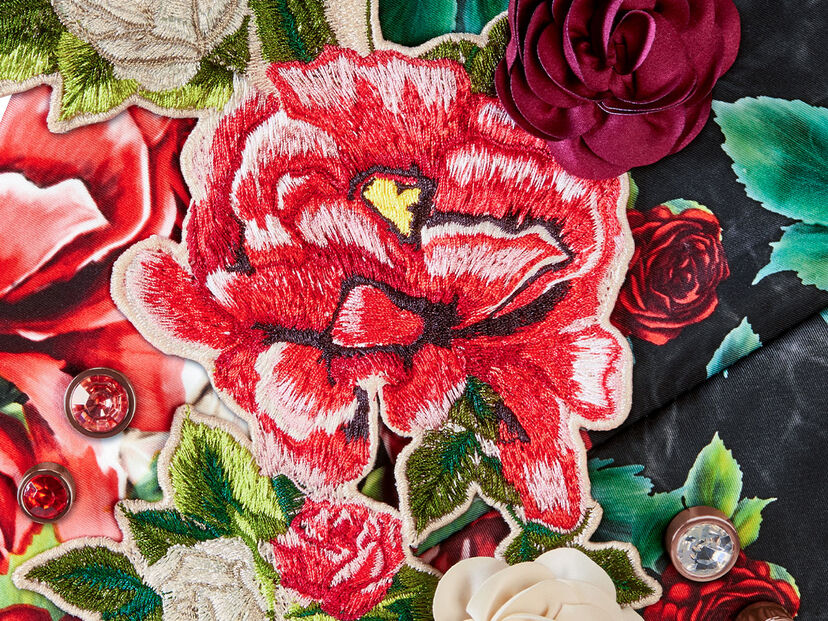 Floral embroidery and embellishments on CYBEX Spring Blossom fabric, featuring red and white roses and gemstones.