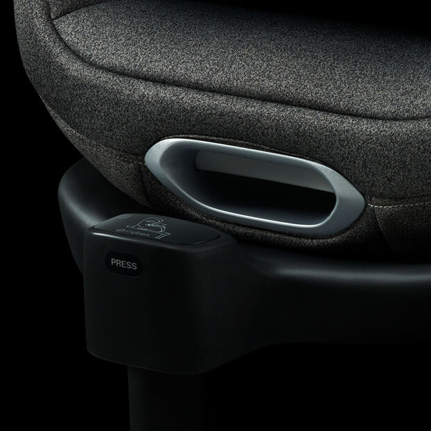 Close-up of Anoris T car seat with grey fabric cover and black base, featuring a press button.