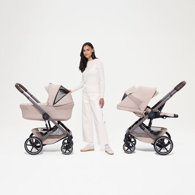  Eine Frau steht neben zwei Balios S Lux Kinderwagen, einmal mit Babywanne, einmal mit Sitzpaket.