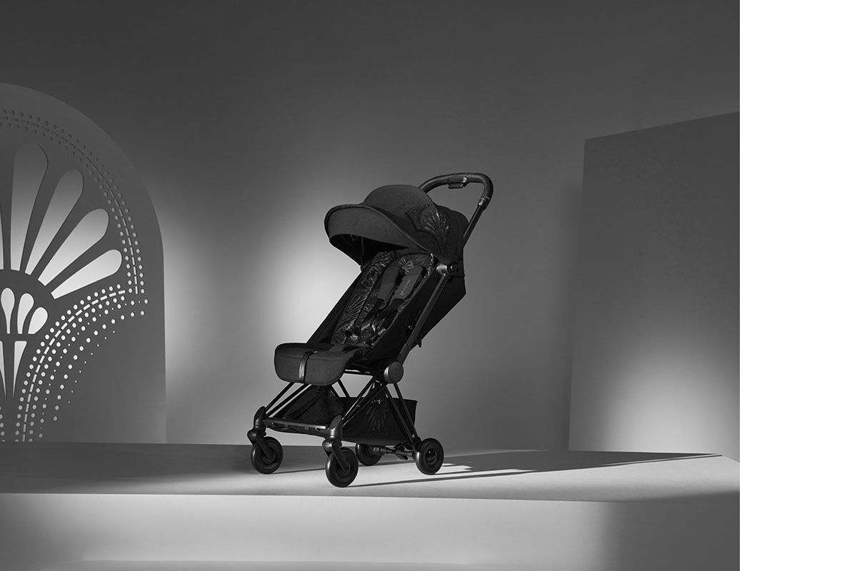 La Parisienne stroller in a stylish black and white studio with decorative background.