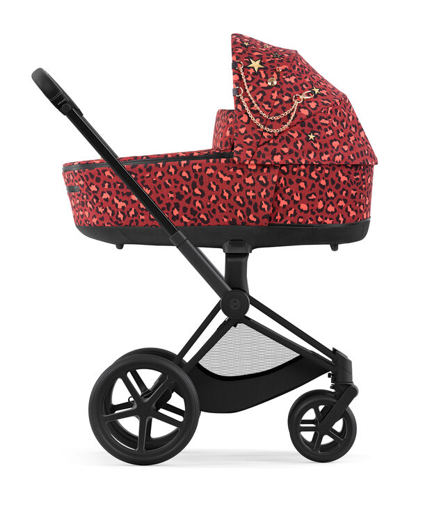 CYBEX Rockstar Kinderwagen mit rotem Leopardenmuster und goldenen Sternen und Ketten auf dem Verdeck.
