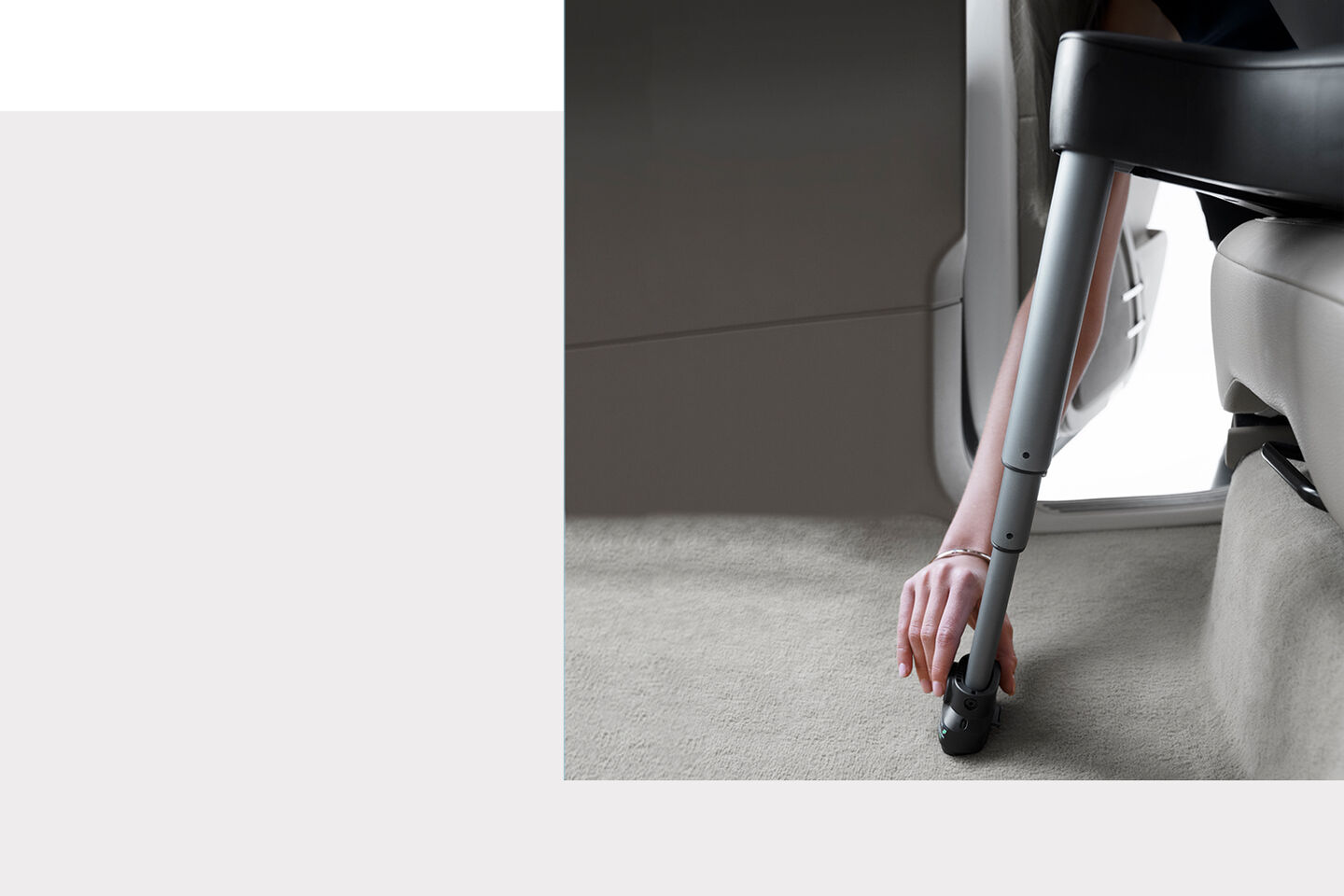 An arm adjusting the load leg of a Sirona S car seat in a vehicle.