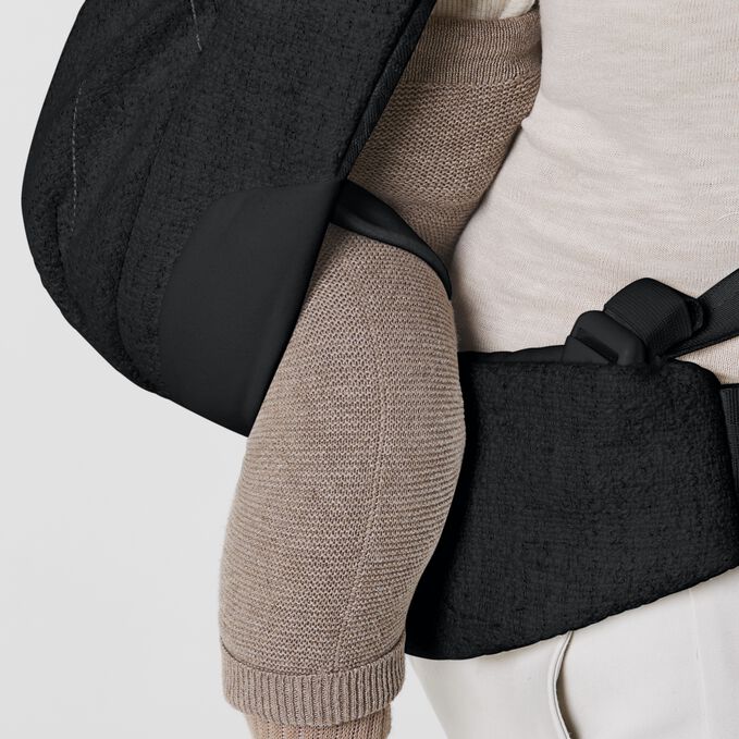 An image of the CYBEX Platinum Coya Carrier Boucl&eacute; Baby Carrier, highlighting the Leg Securing Straps feature.