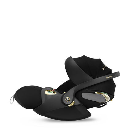 by Jeremy Scott Wings, a sleek black car seat with gold accents and a modern design.
