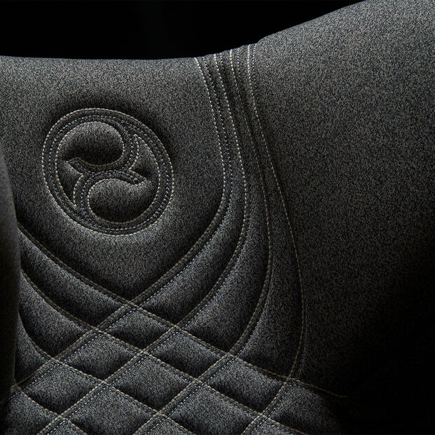The image shows a close-up of the Anoris T seat cover with an embroidered logo and detailed stitching.