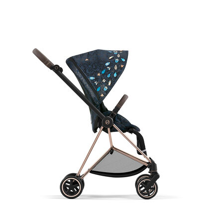 Pushchair with a blue, embellished canopy and gold details, viewed from the side.