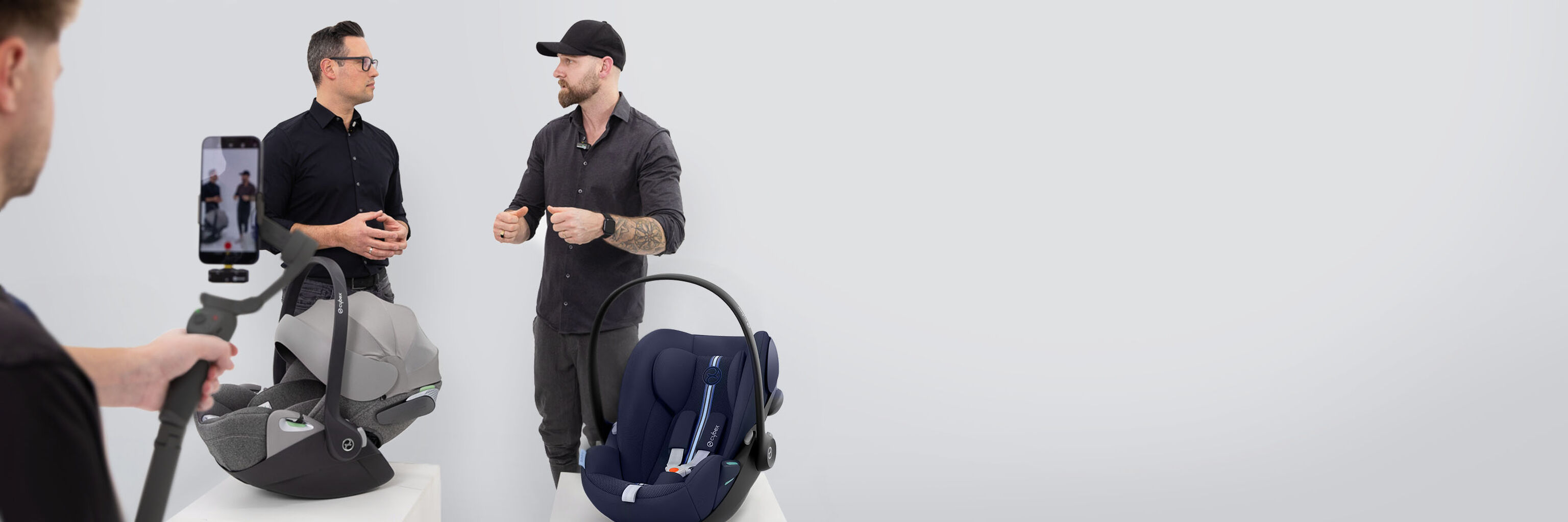 A man films two men discussing CYBEX Live car seats.