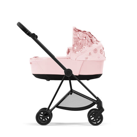CYBEX Simply Flowers barnvagn i rosa med blommiga dekorationer p&aring; huven, sidovy.