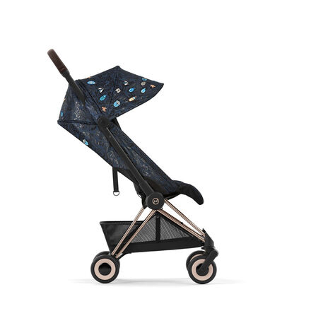 Stroller with dark blue pattern and colourful embellishments, side view.