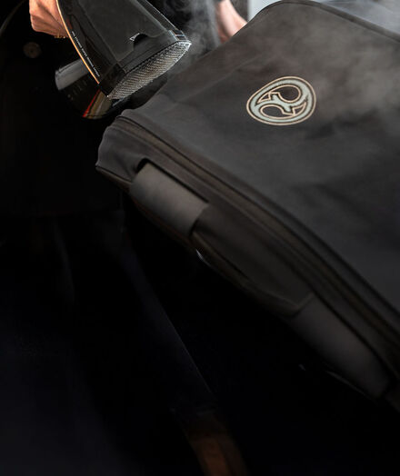Someone is steaming a CYBEX stroller, cleaning it.
