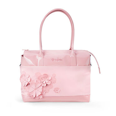 Eine zartrosa CYBEX Simply Flowers Wickeltasche mit rosa 3D-Blumenapplikationen, von vorne fotografiert, im Studio vor wei&szlig;em Hintergrund.