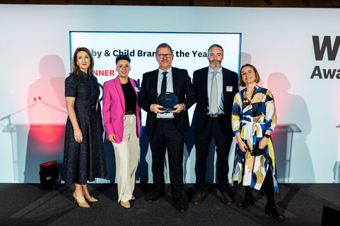Five people standing on a stage holding an award.