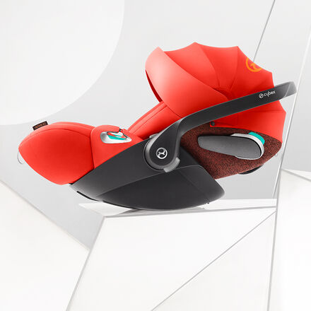 A red Cybex car seat with ergonomic design on a white background.