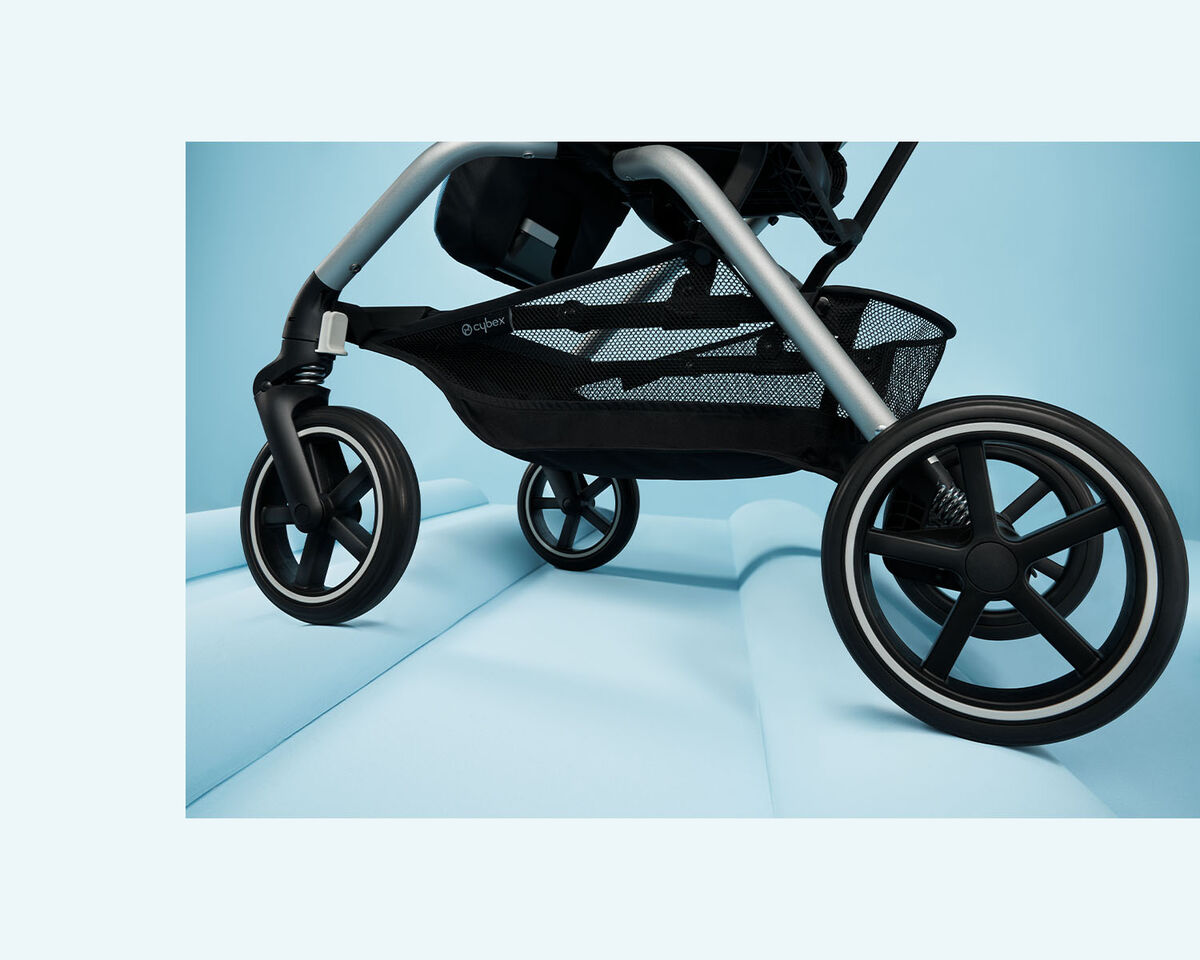 Eezy S Twist +2 pushchair on a light blue background, focusing on the front wheels.