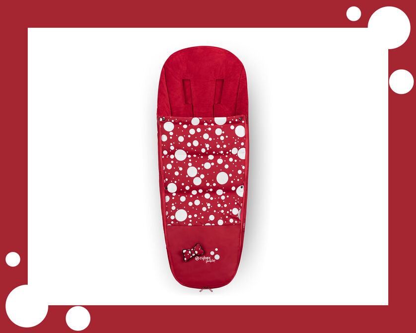 Red pram footmuff with white polka dots and a bow at the bottom.