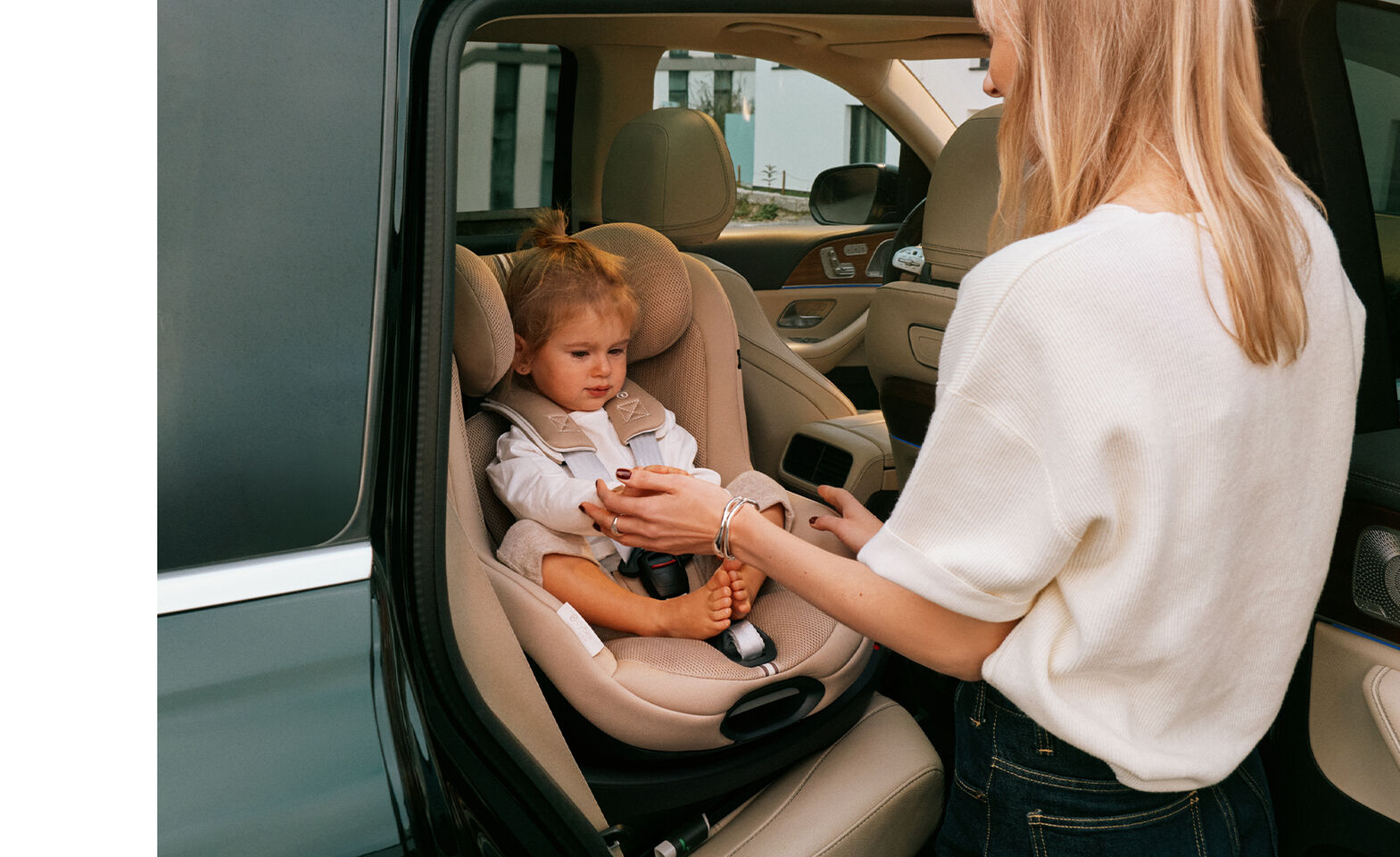 A woman taking her daughter out of the car, the Sirona G3 that the little girl is sitting in is turned towards the door.