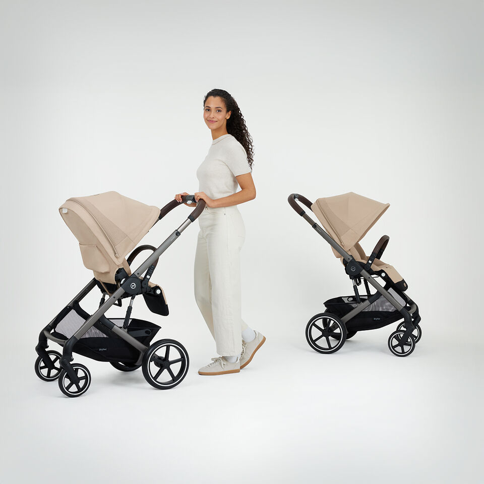 A woman pushing a Balios S Lux stroller with a seat pack facing her while next to her is a Balios S Lux with a seat pack that's facing the world.