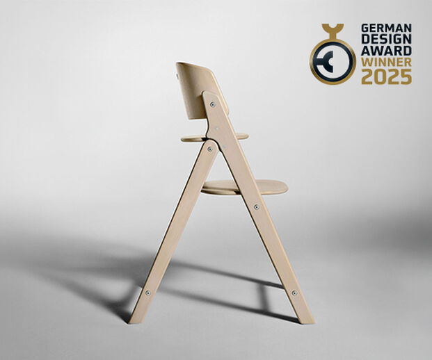 Side view of the Click and Fold high chair made of light wood on a grey background.