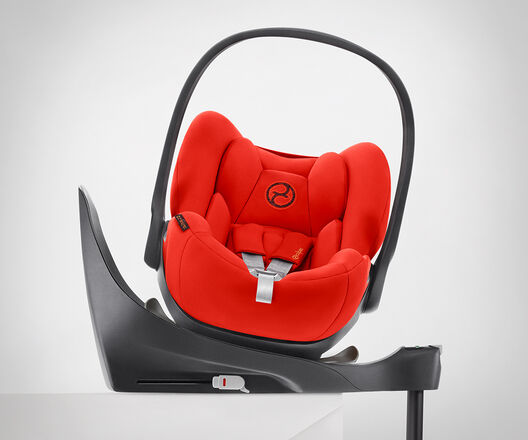 Kindersitz in leuchtendem Rot mit schwarzem Griff und grauer Basis auf wei&szlig;em Hintergrund.