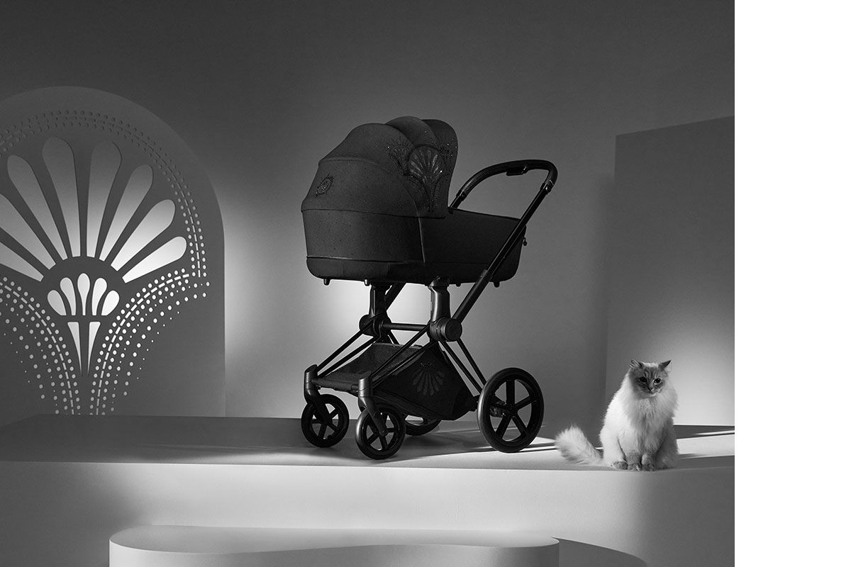 La Parisienne pram in a stylish black and white setting with a cat beside it.
