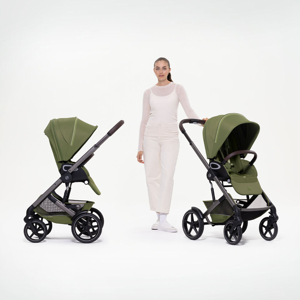 Eine Frau steht zwischen zwei Talos S Lux Kinderwagen, die Sitzeinheiten in verschiedenen Richtungen.