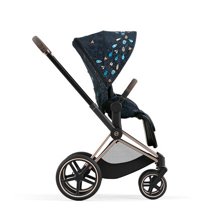 Stroller with dark blue patterned canopy and gold details, side view.